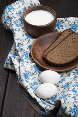fresh bread on a wooden plate with cream and eggs on a countryside style