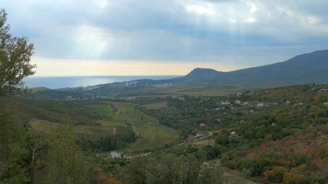 Panoramic landscape of mountains and sea in autumn / Panoramic image of mountains, valleys and the sea with a quick passing clouds over them in the autumn overcast day