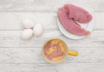 raw meat turkey on the plate, eggs,  meal nuggets
