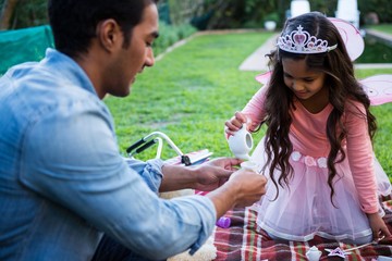 Father and daughter having toy tea party