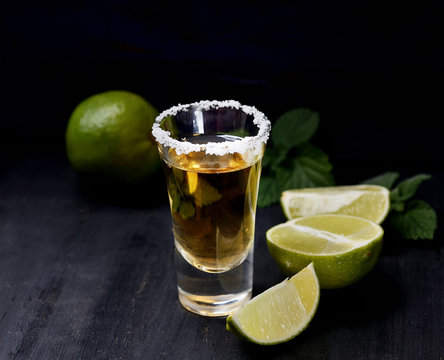 Tequila with salt and lime on a dark background