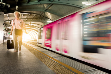 Motion burred sky train and man on station