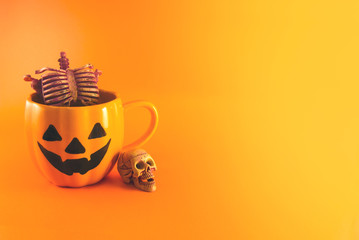 skeleton in the cup on orange background