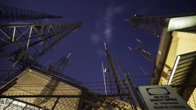 Time Lapse with tilt up motion of broadcast radio tower at night shot through storm clouds at Mt. Wilson, California