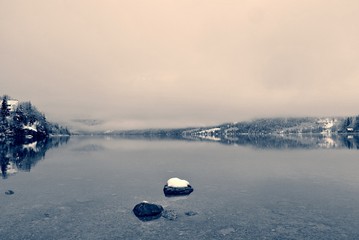 Snowy winter landscape on the lake in black and white, on a cloudy, foggy day. Monochrome image filtered in retro, vintage style with soft focus and red filter. Lake Bohinj, Slovenia - 123013784