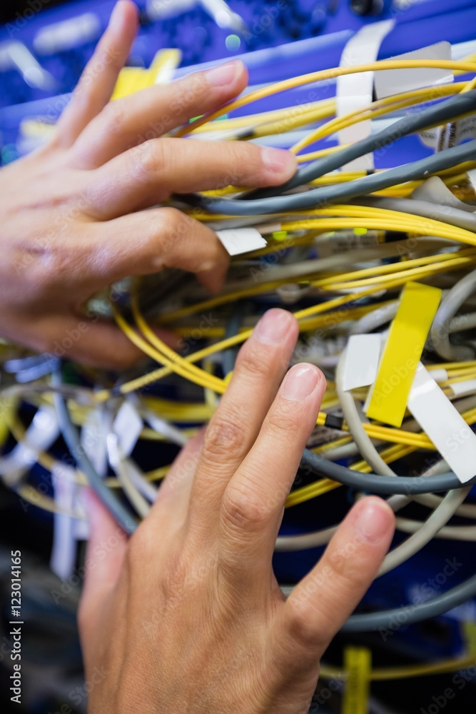Poster Technician checking cables in a rack mounted server