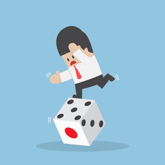 Businessman standing on unstable dice