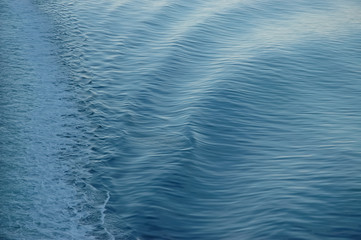 Fototapeta na wymiar white backwash of a ferry crossing blue ocean