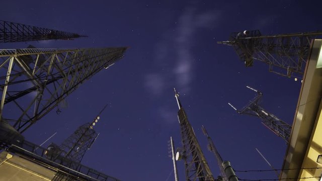 Time Lapse with zoom out motion of broadcast radio tower at night shot through storm clouds at Mt. Wilson, California