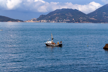 Fisherman on a Fishing Boat - Liguria Italy. In the background Portovenere