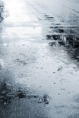 rain drops on wet asphalt. wet street pavement during rain in autumn season.