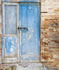 The blue door of an old abandoned rural farmhouse in the Tuscan countryside (Italy).