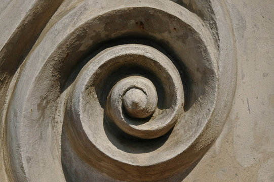 Abstract swirl circular art icon on concrete wall