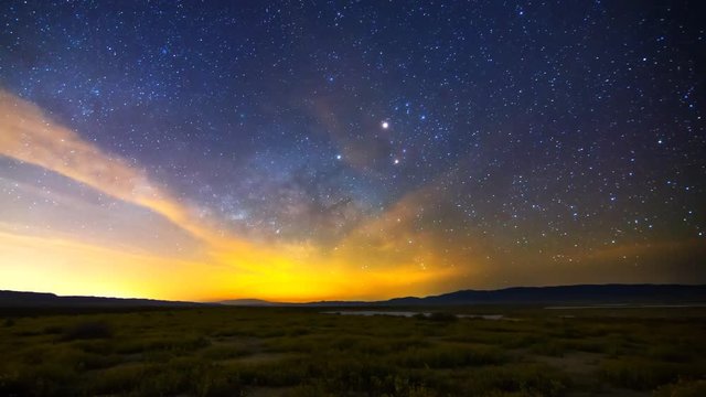 Astrophotography time lapse with pan left motion of Milky Way galaxy rising over Desert Gold wildflower super bloom 2016 in Carrizo Plain National Monument, California