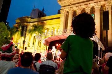 Kid stands to enjoy concert at night