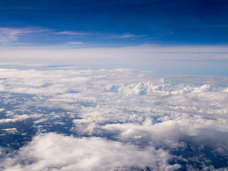 Fototapeta na wymiar Cool soft unique white cloud and blue sky view from window of airplane while flying over Thailand.
