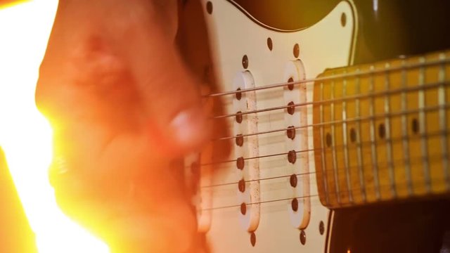 Closeup Guitarist Runs Fingers over Neck Strings in Night Bar