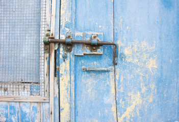 Old latch on a wooden blue door in Tuscany, Italy.