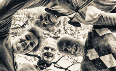 Four elder people looking down to camera relaxing happy outdoor