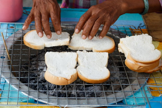 Grilling bread with stove street food in Thailand topping with jam or butter and sugar, selling on two pieces five baht thai