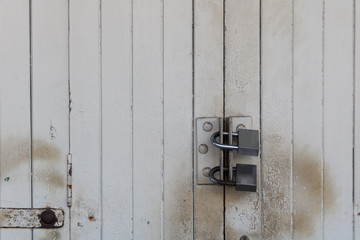 Old wooden door locked with golden padlock - Old town in Thailand