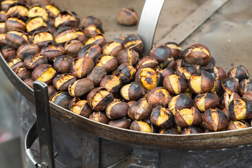 Roasting chestnuts on the grill by a street vendor in  Rome, Italy