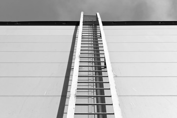 Metal ladder on industrial building in black and white style