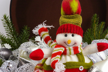 Funny snowman sits on vintage brown coffer with white christmas