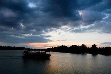 Silhouette of tourist boat on Tapee river Suratthani Thailand in evening time