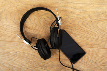 Headphones and phone on a wooden surface