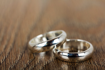 Obraz na płótnie Canvas pair of wedding rings on a wooden background