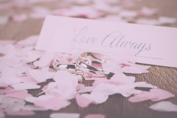 wedding rings on a wooden background with confetti Vintage Retro