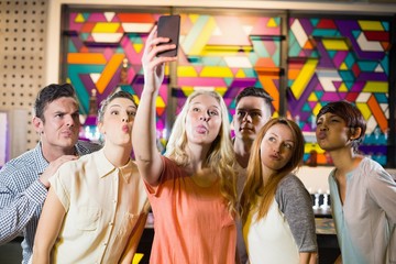 Group of smiling friends taking a selfie from mobile phone