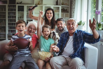 Happy family watching soccer match on television
