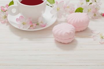 Red tea with flowers on white wooden background