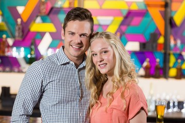 Fototapeta premium Cute couple standing together in bar