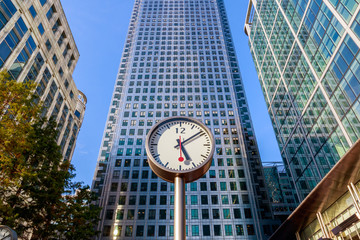 Fototapeta na wymiar Clock and skyscrapers in Canary Wharf, financial district of London