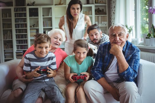 Family watching the kids playing video game