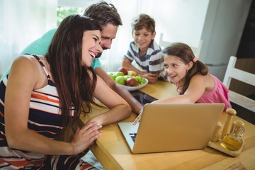Family using  laptop at dinning table