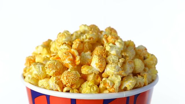 Cheese popcorn rotates on a white background. Close up shot