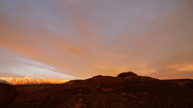 Time lapse with tilt down motion of morning glow over Native American Petroglyphs in Eastern Sierra, California