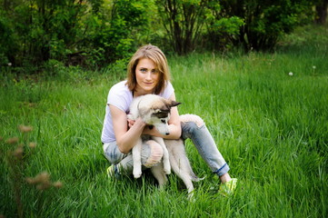 A girl and her dog husky walking in a park