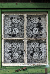 Old window curtain.White window with lace curtain of an old wooden rustic Bavarian house. Munich,Germany