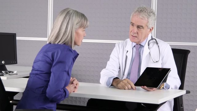 Doctor using digital tablet with patient