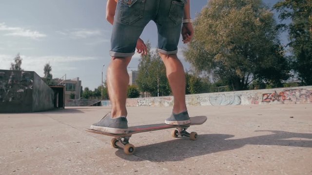 Skateboarder ruising down the city street. Slow motion, close up. HD.