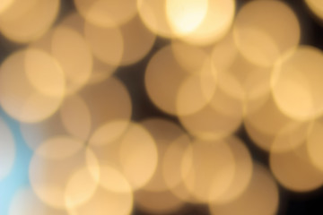 golden bokeh on a black background, abstract dark backdrop with defocused warm lights and blue highlight