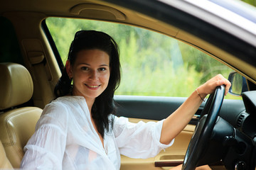 Obraz na płótnie Canvas Beautiful Woman sitting inside the car in a white shirt