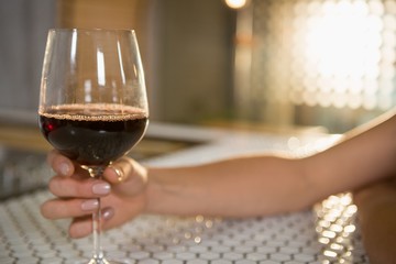 Woman having red wine at bar counter