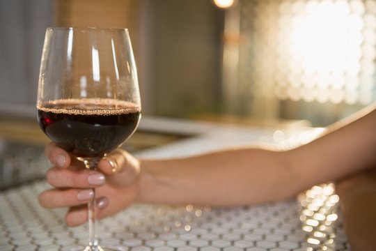 Woman having red wine at bar counter