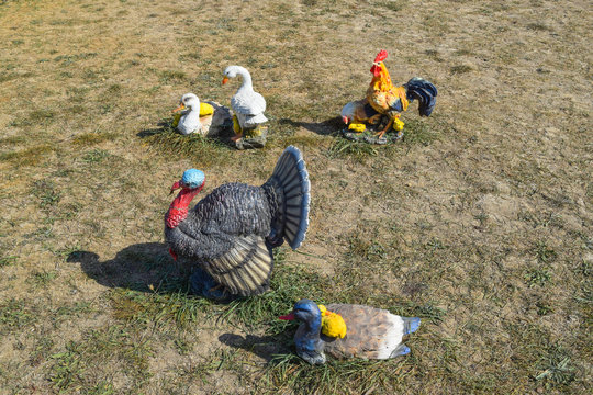 Toy turkeys and chickens in the meadow. Home decorations of the house